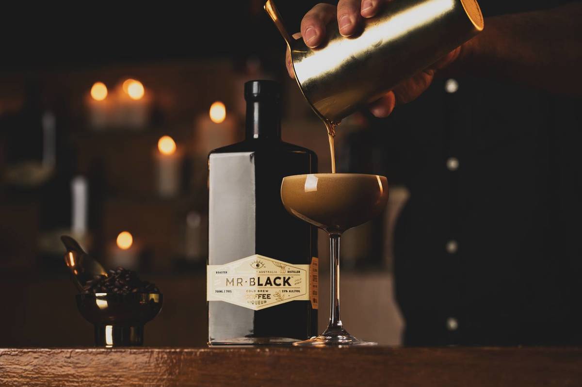An Espresso Martini is being poured next to a bottle of Mr Black