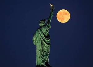 Statue of Liberty Gazing at the Harvest Moon as it Rises taken from Liberty Park in New Jersey