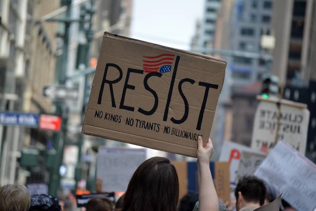 NEW YORK, NEW YORK USA - April 19, 2025: People holding signs at an Anti-Trump protest against the current administration's actions on immigration and civil rights in Midtown Manhattan.