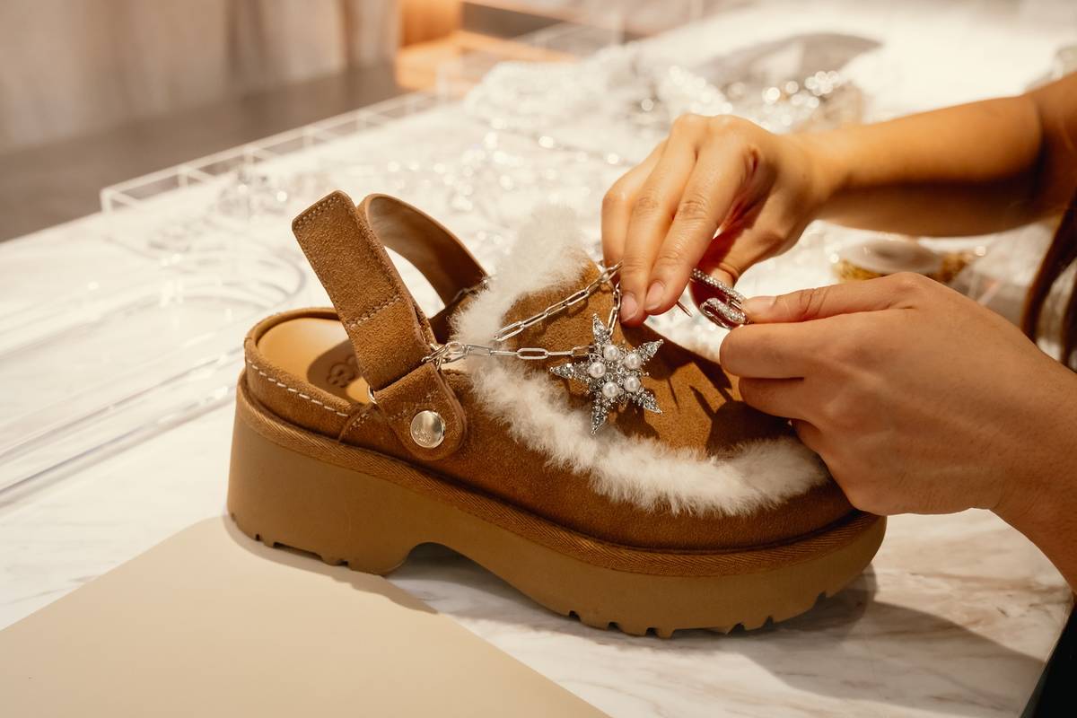 Close up of someone adding an UGGlet charm to their UGG loafers at the Feel House pop up