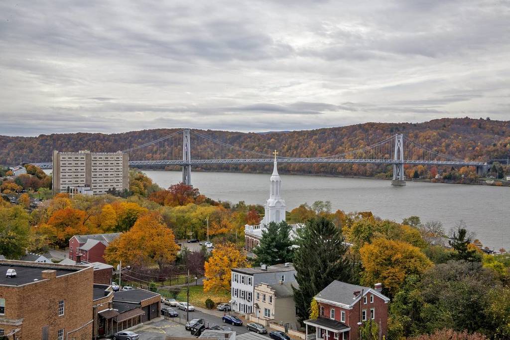 Uma vista da cidade de Poughkeepsie, Nova York, no outono, com a ponte Mid Hudson atravessando o rio Hudson.