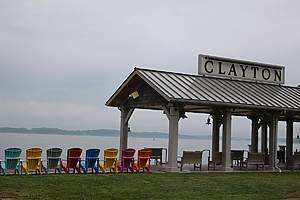 View of colored adirondack chairs and a waterfront pagoda at dusk in Clayton, New York, a riverside tourist destination in the Thousand Island region of upstate New York.