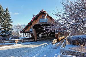 Holz Brucke wooden covered bridge in Frankenmuth Michigan surrounded by a snowy winter scene