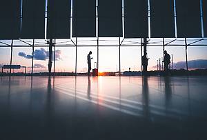 people in airport with sunset in background