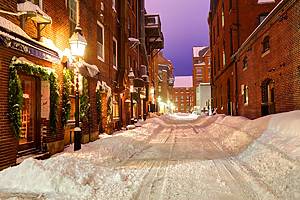 Snow covered narrow city street in Historic Portland, Maine. Portland is the largest city in the state of Maine located on a penninsula extended into the scenic Casco Bay. Portland is known for its maritime services, boutique shops,cobbleston streets, fishing piers, vibrant art district and fine dining.
