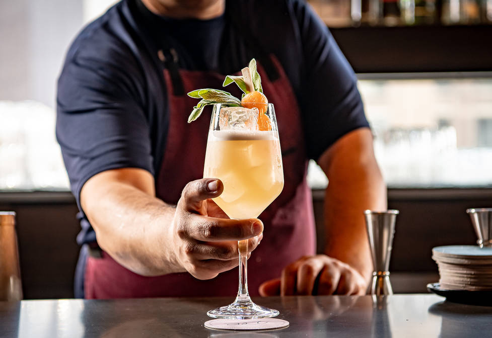 Bartender serving up a spritz at ART Soho bar in NYC