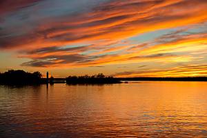 New York, Ogdensburg. Sunset over the Oswegatchie River junction with the St. Lawrence Seaway. Ogdensburg Harbor Lighthouse.