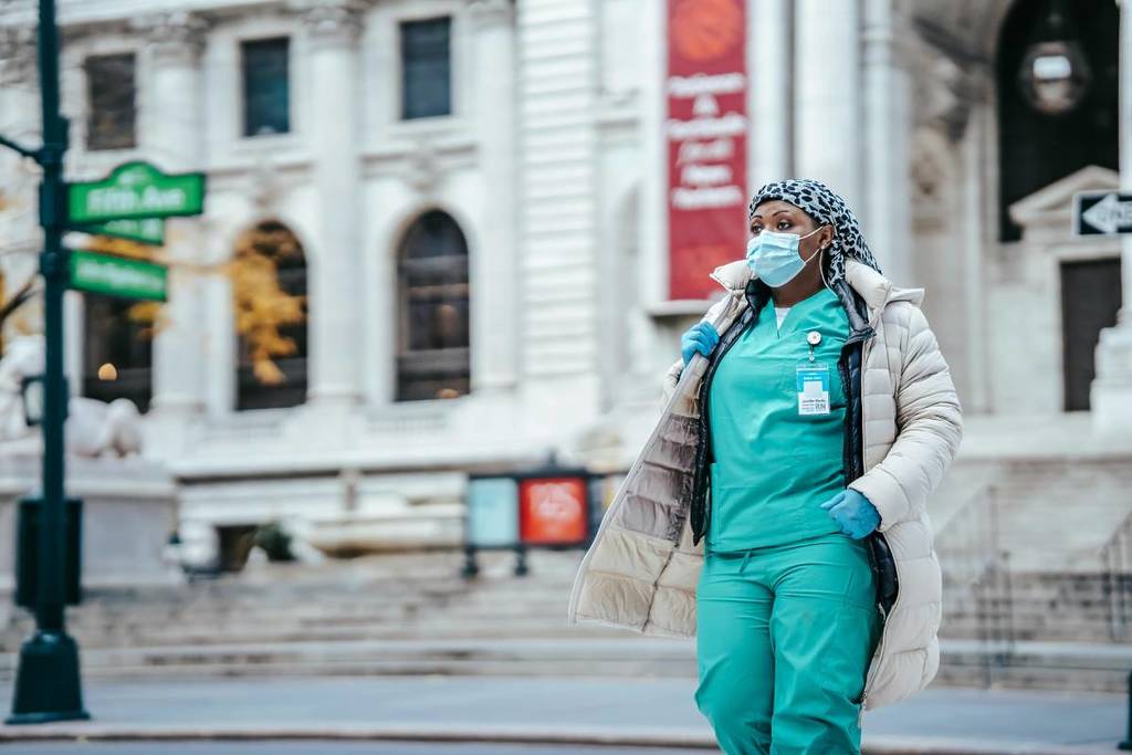 Un médecin portant un masque stérile marche sur une route de la ville de New York