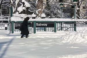 person walking near the nyc subway covered in snow