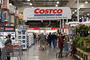 Tigard, OR, USA - Nov 29, 2021: Shoppers in a Costco Wholesale store in Tigard, Oregon, during the holiday season. Selective focus on the Costco banner.