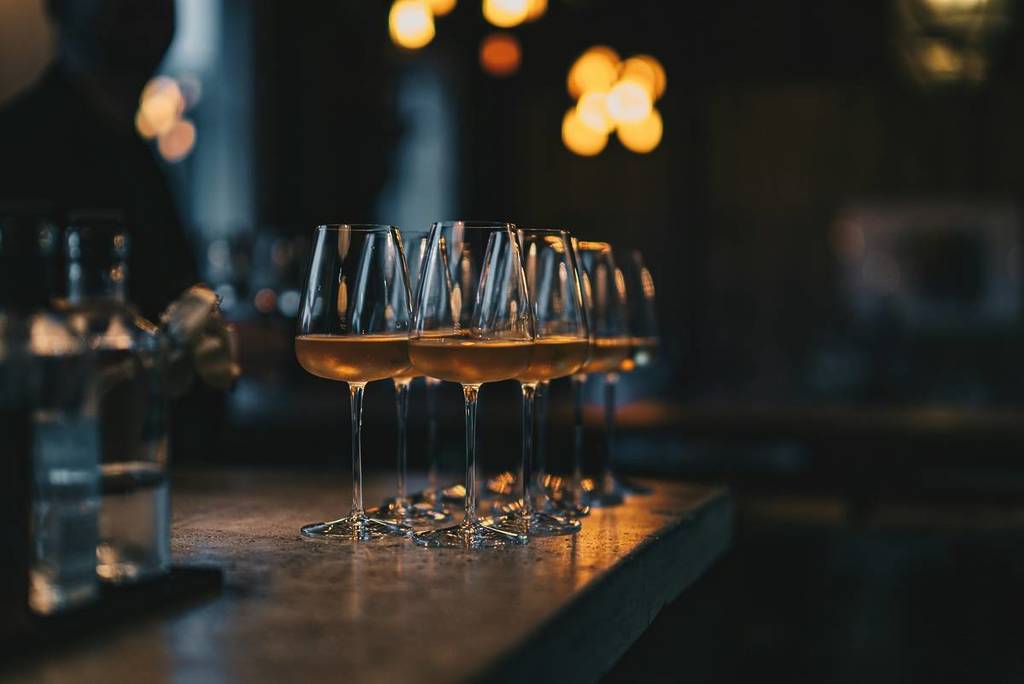 Copas de vino blanco llenas colocadas en una barra durante una cata de vinos