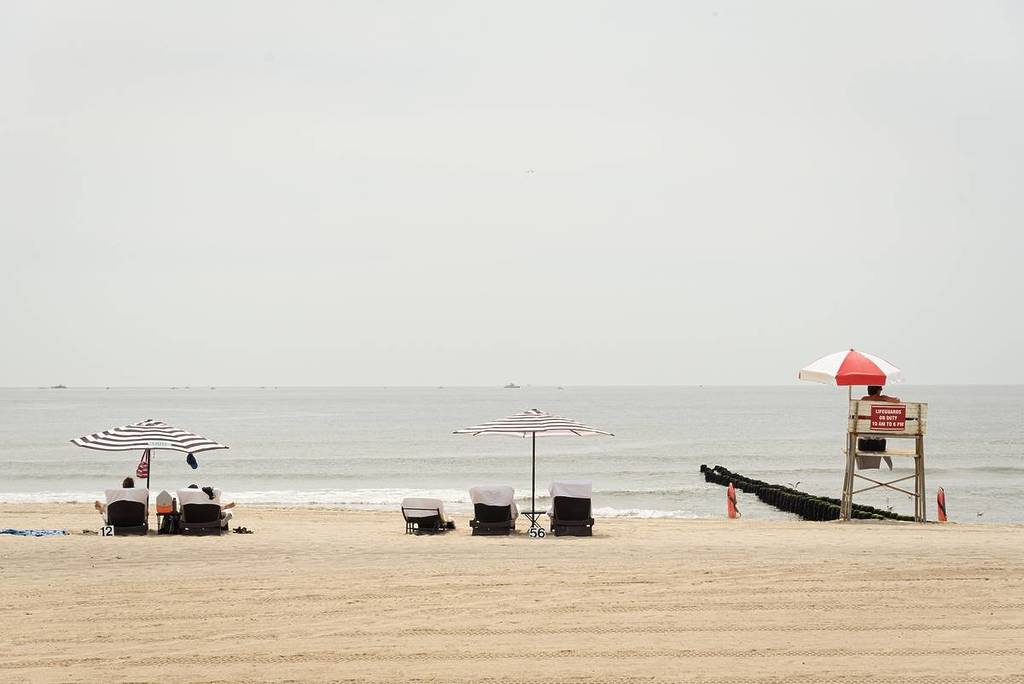 Umbrellas and lifeguard stand on the beach, at Jacob Riis Park, in the Rockaways, Queens, New York City