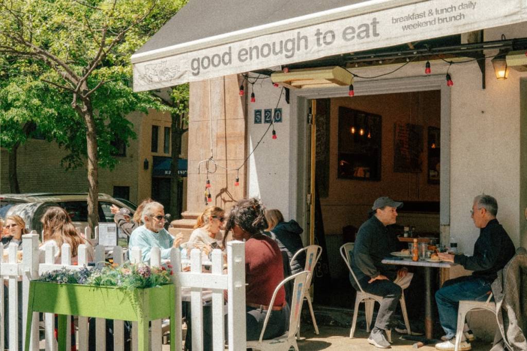 mensen die buiten bij Good Enough to Eat zitten te eten