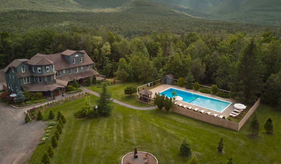 Just 2 hours from NYC, this Michelin Guide 1890s Catskills estate features one of the region’s largest pools, yoga overlooking the mountains, &amp; fireside acoustic sets