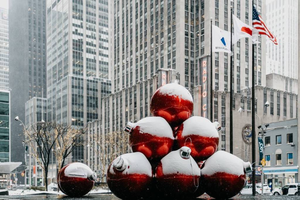grandes adornos navideños rojos en Nueva York cubiertos de nieve