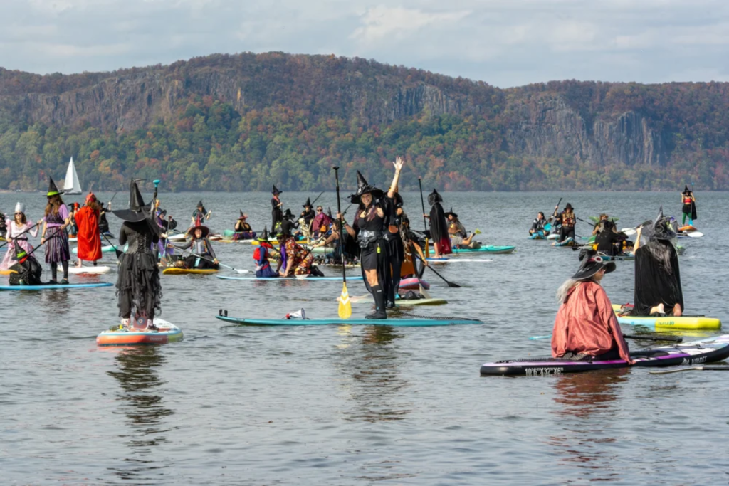 des sorcières faisant du stand-up paddle sur l’Hudson pendant le SUP Witches Festival