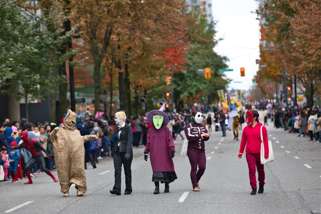 Leute, die in Halloween-Kostümen die Straße entlanglaufen