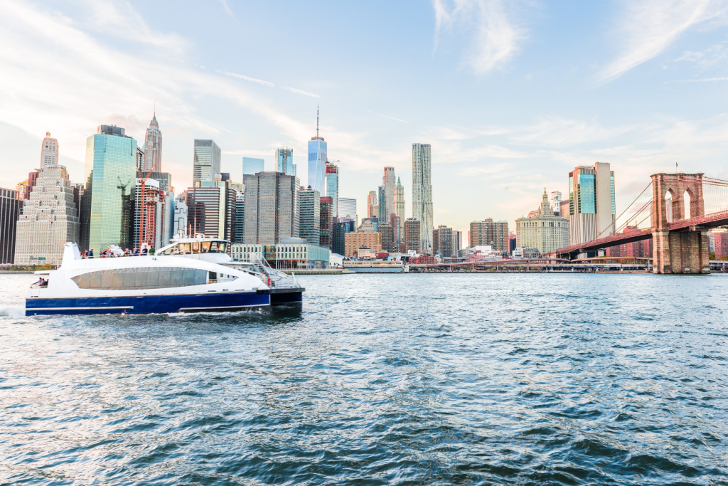 Blick ins Freie in NYC, New York City, Brooklyn Bridge Park am East River, Stadtpanorama und Skyline bei Sonnenuntergang, Wolkenkratzer, Gebäude, Ausflugsboot, Menschen, Touristen