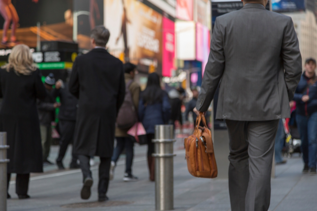 Des hommes d’affaires avec une mallette se promenant dans le quartier de Times Square à New York