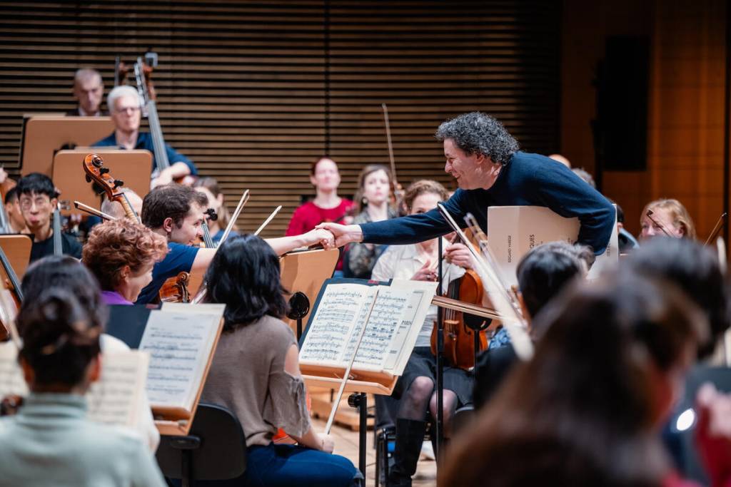 Dudamel shaking hands with a member of the NY Philharmonic during rehearsal