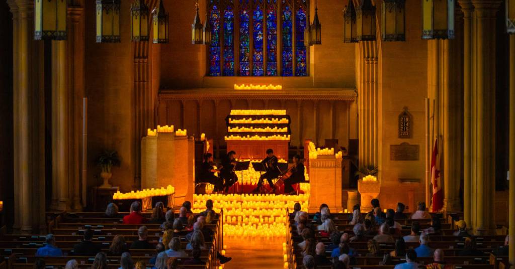 A string quartet performing at Knox Church in Ottawa surrounded by a sea of candles
