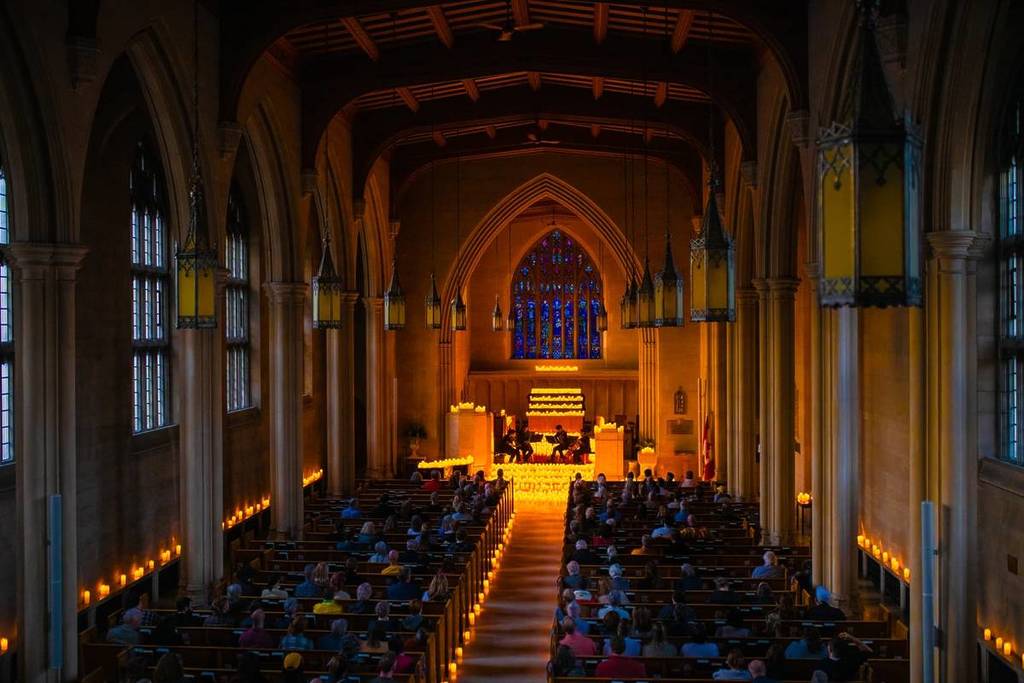 the interior of knox church illuminated by thousands of candles at a candlelight concert in ottawa