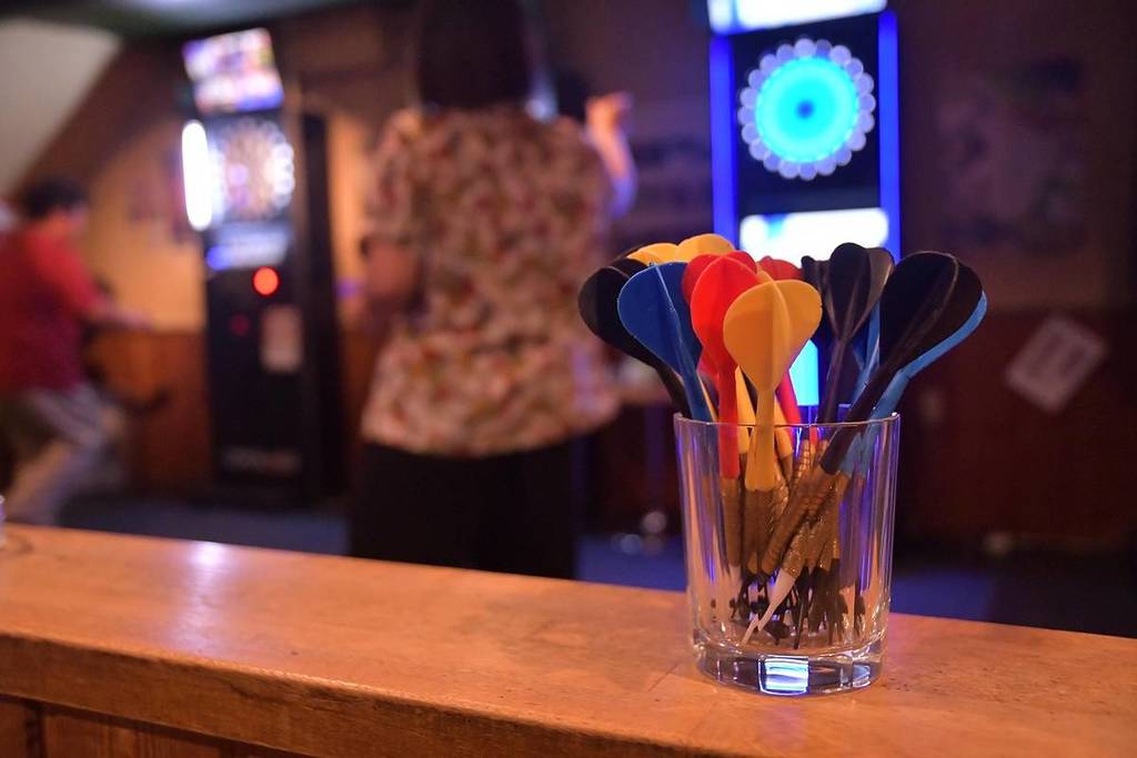 Darts in a cup on the bar top