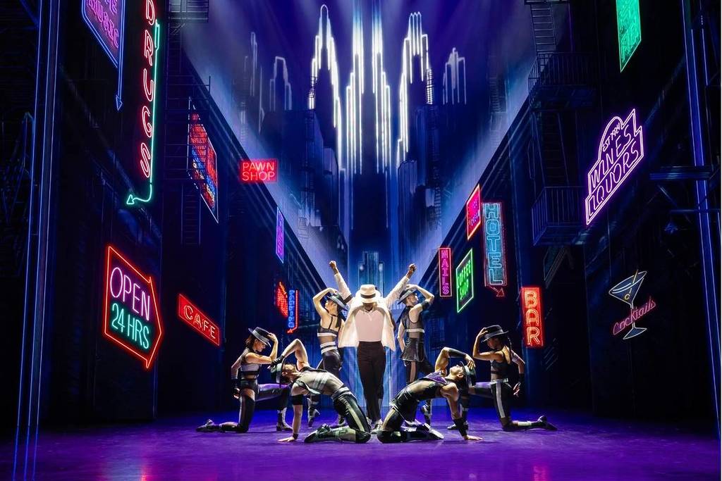 The image shows characters from MJ-The Musical, with the protagonist in the centre with his arms raised surrounded by dancers. It is part of the upcoming musicals in Perth.