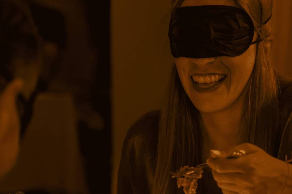women wear blindfolds as part of dining in the dark experience