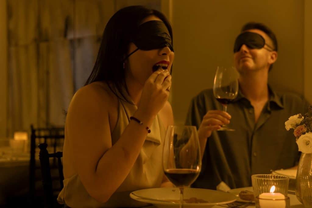 A woman eating at the Dining in the Dark experience.