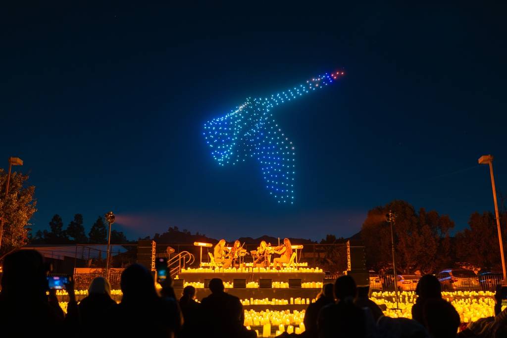 Illuminated drones fly over a candlelit string quartet