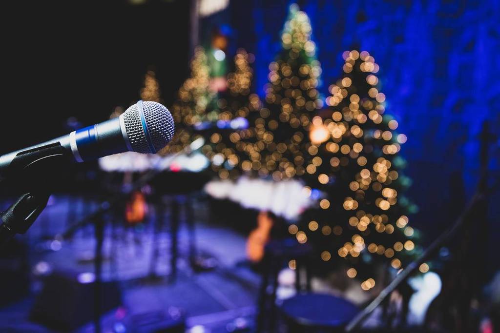 standing mic in front of Christmas trees