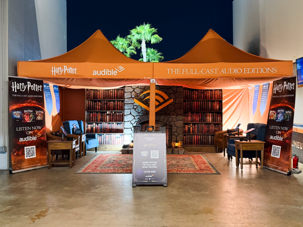 audible listening tent with armchairs, rug and mock bookshelves around a mock fireplace