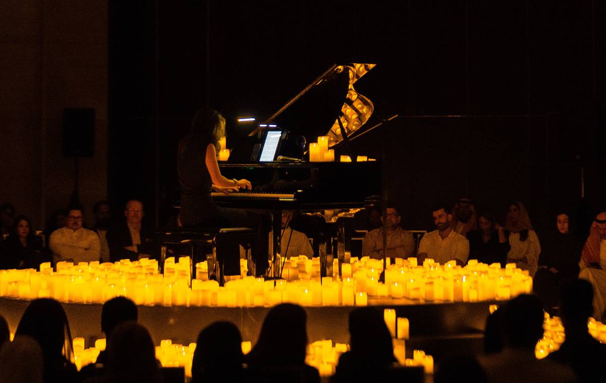 Pianista suona su un palco circondata da migliaia di candele
