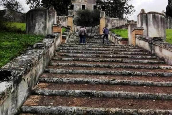 A escadaria monumental em pedra que desce em direção ao ninfeu da Villa York, no parque da propriedade em Roma
