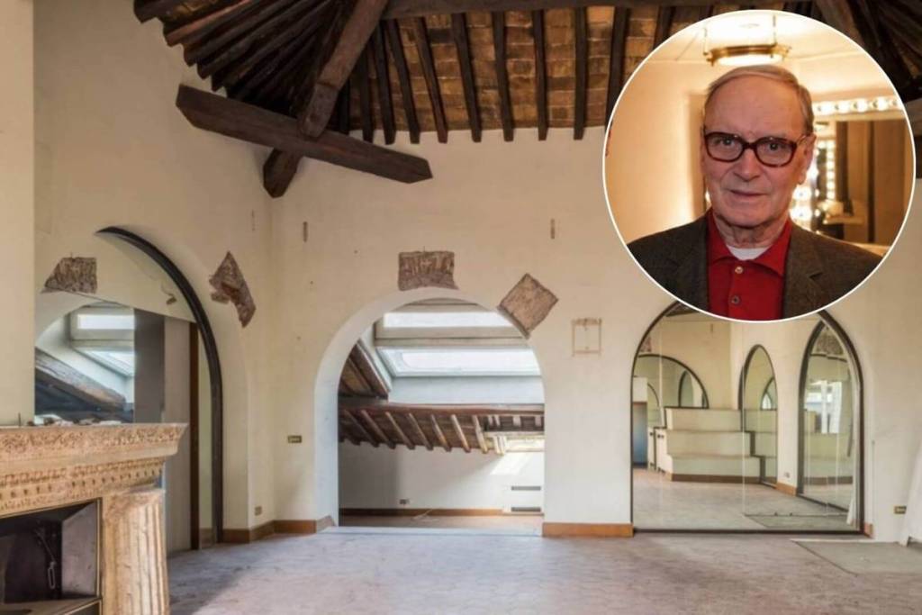 Soggiorno con travi a vista dell'attico di Ennio Morricone a Roma; in inserto, ritratto del noto compositore.