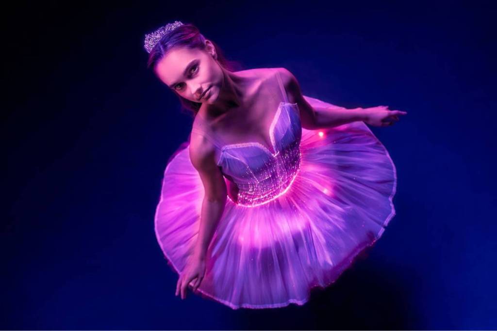 A ballerina performs in a pink dress at Ballt of Lights.