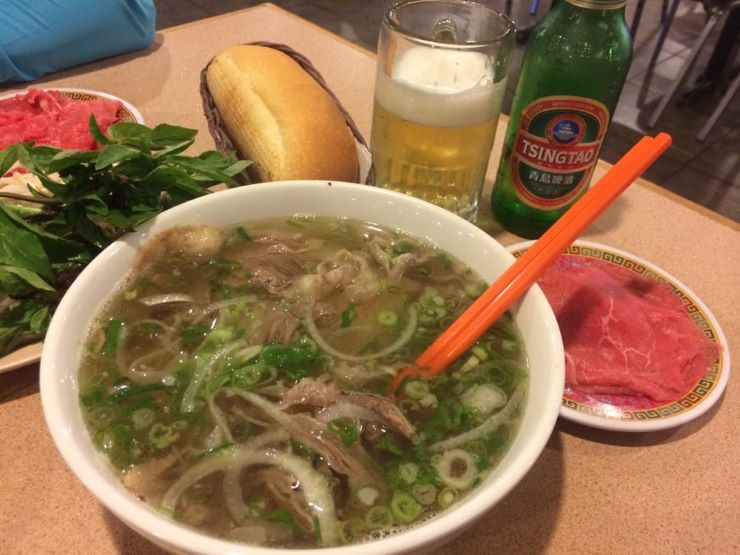 bowl of clear broth and noodles in pho dish