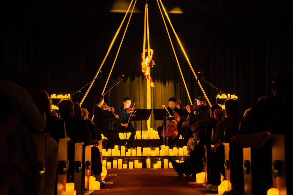 Un trapecista actúa en un concierto a la luz de las velas.