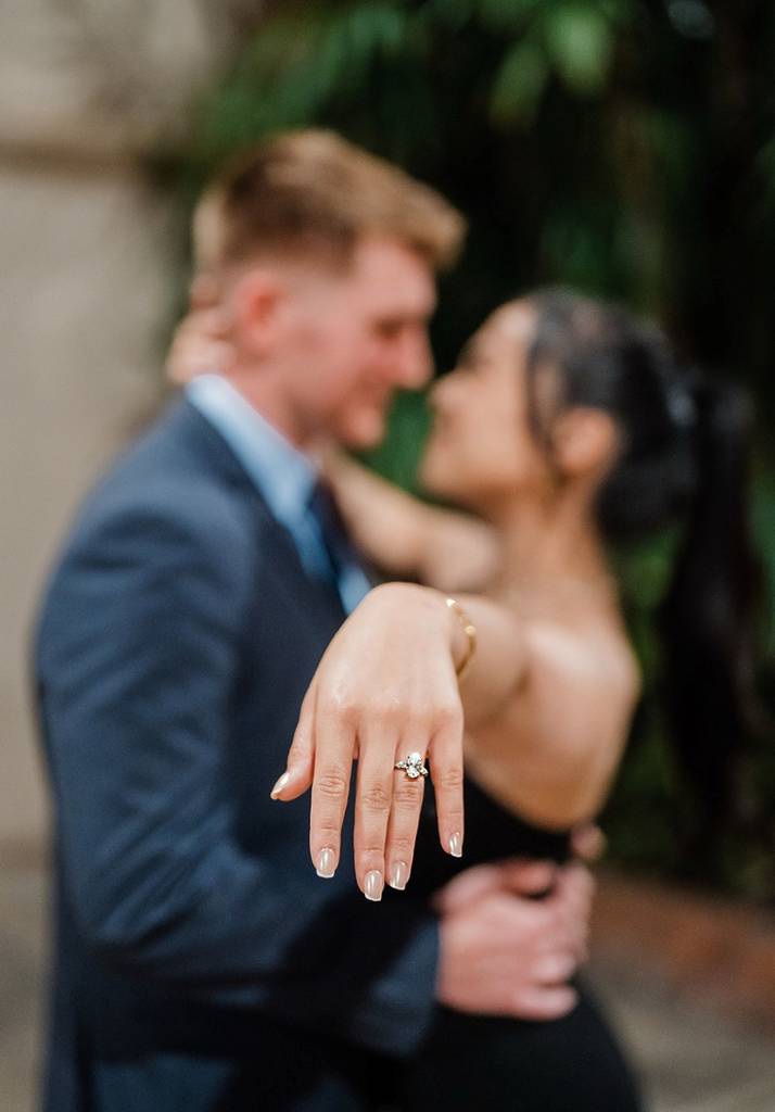 couple posing after getting engaged with the ring in focus