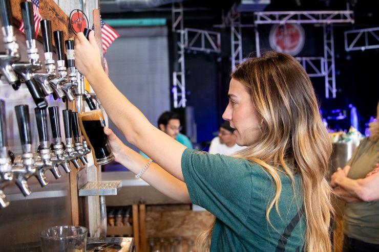 woman pouring beer at a beer fest in San Diego