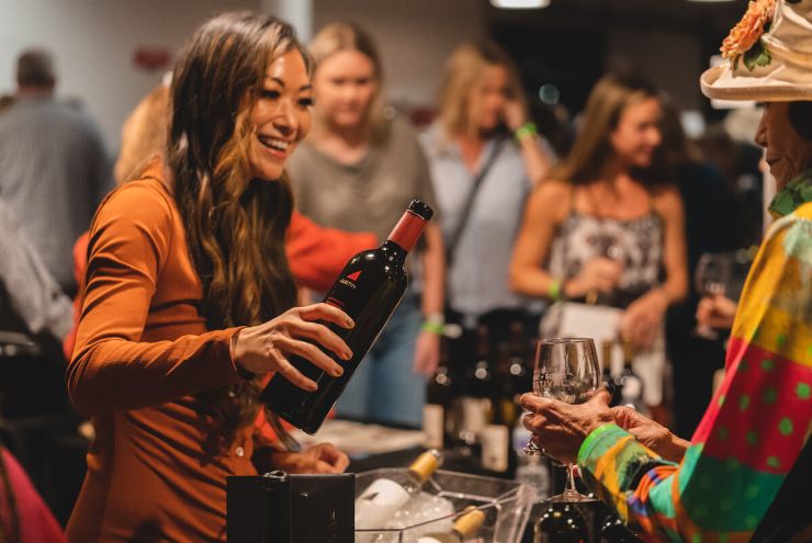 woman pouring wine at a festival in San Diego