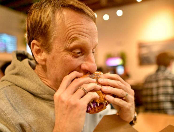 Tony Hawk eating a sandwich at his restaurant