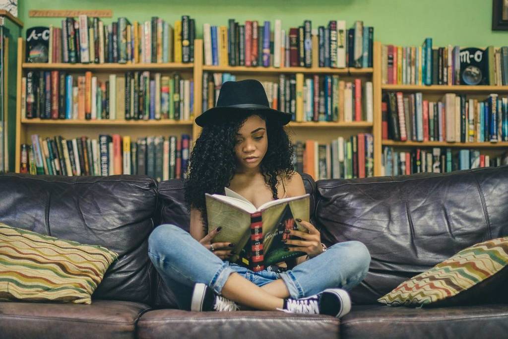 woman reading a book on a couch