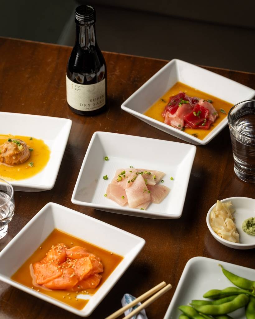 a tables filled with Sushi and other Japanese plates