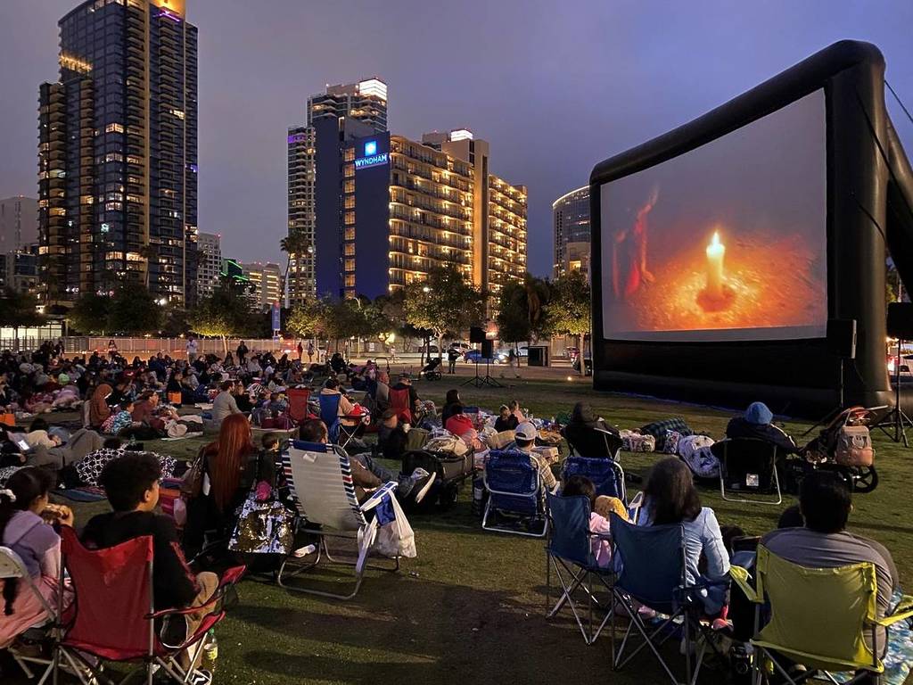 gente viendo una película en el parque