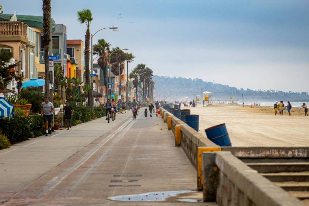 people running and walking by a beach in San Diego
