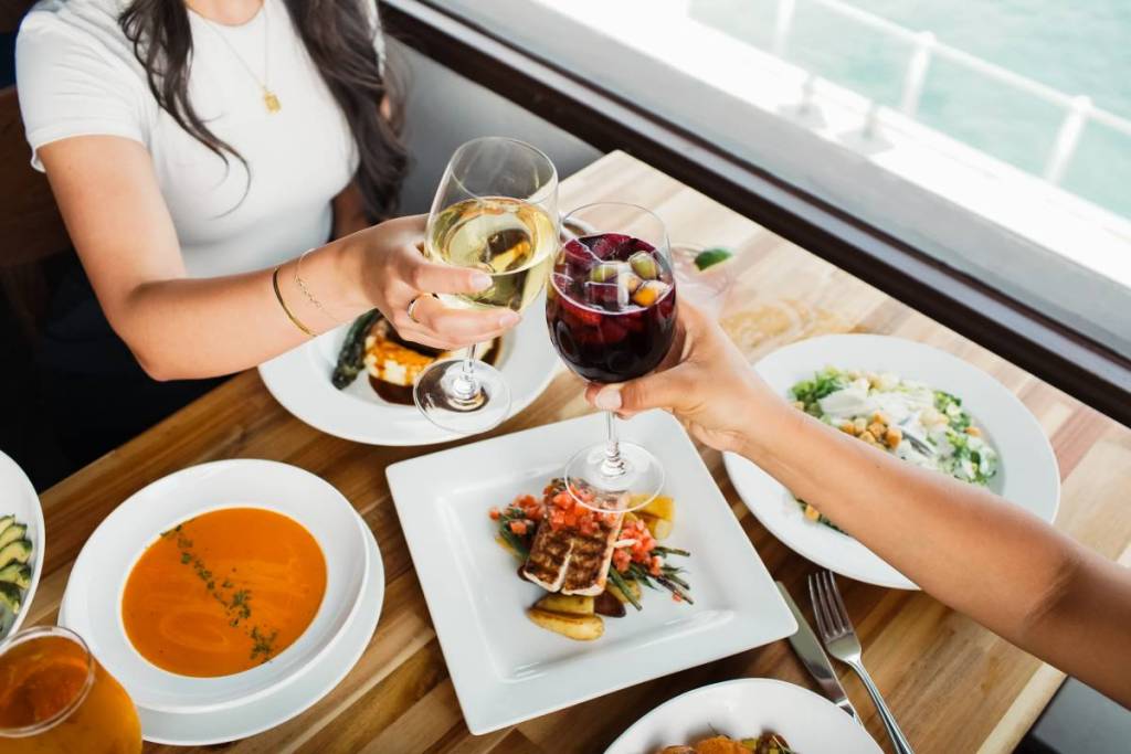dos mujeres almorzando junto al agua durante la Restaurant Week