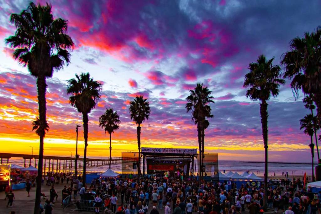 people at a beach side Oktoberfest