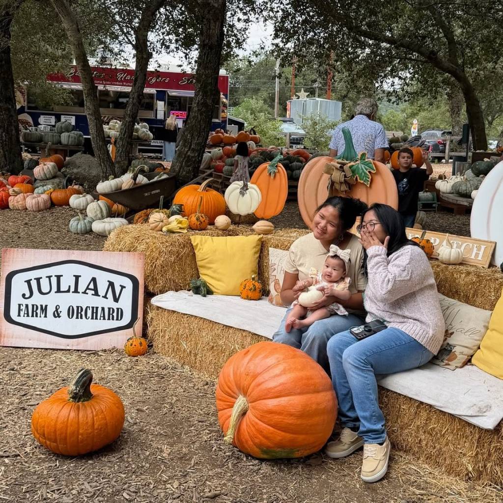 family posing by a pumpkin patch
